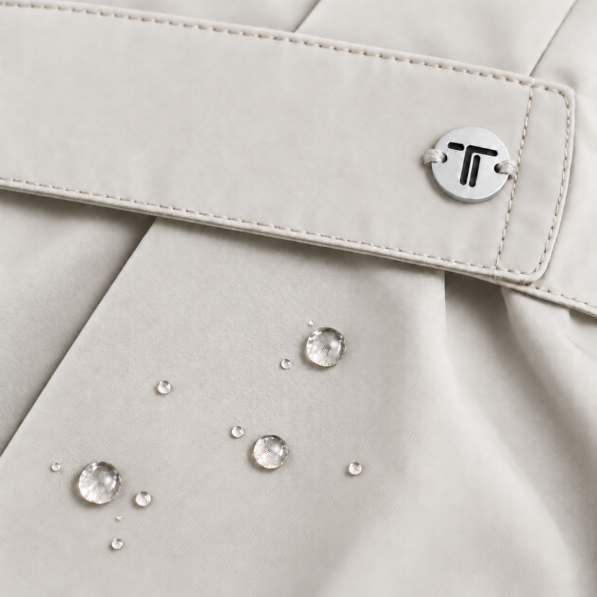 Dettaglio giacca beige chiaro: patta con fibbia metallica e punti decorativi